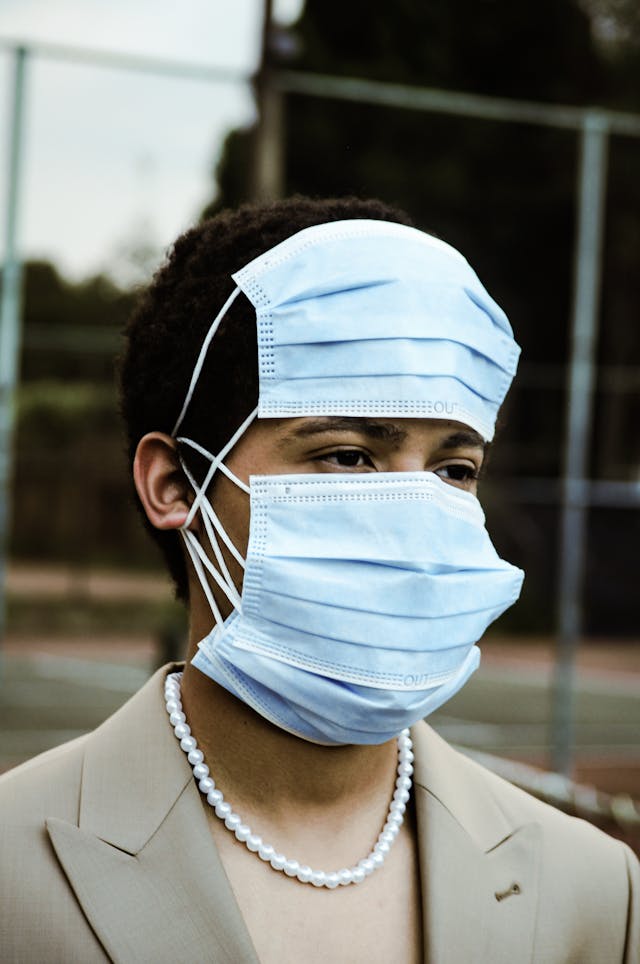 Man with face covered in surgical masks so that only his eyes show.