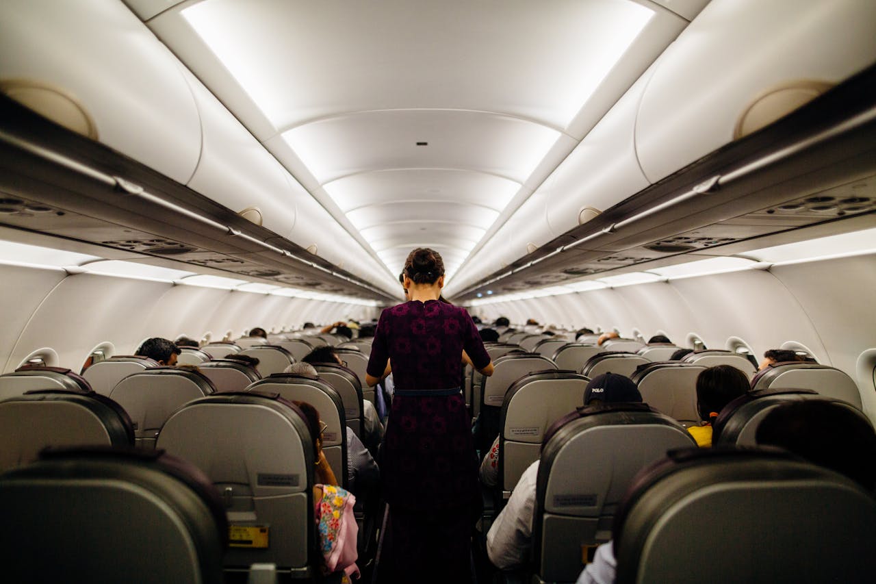 Interior of commercial aircraft. Steward walking down the aisle